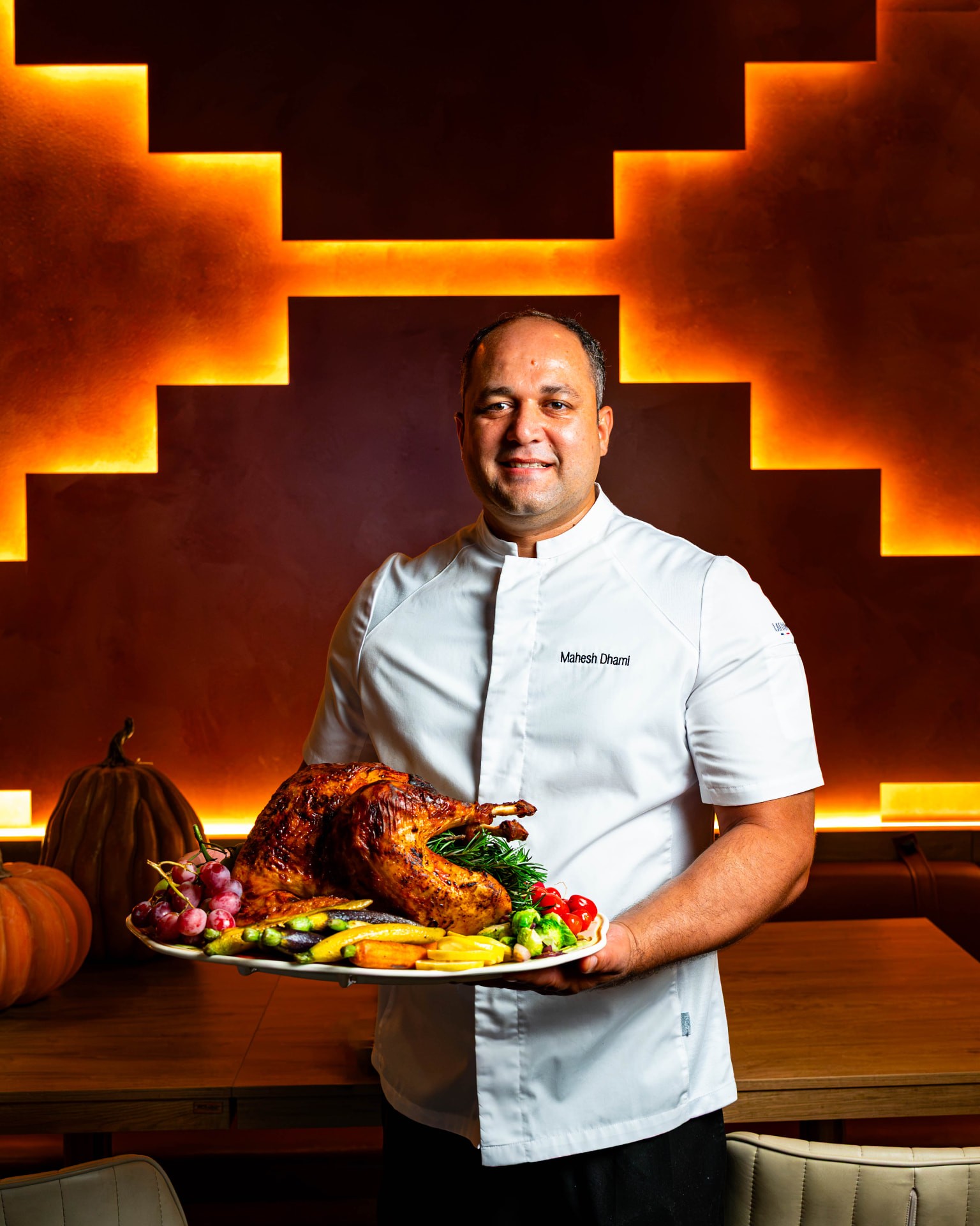 Chef presenting a signature dish in a warmly lit dining room
